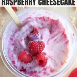 A creamy raspberry cheesecake mix in a glass bowl, crowned with fresh raspberries. A gold spoon plunges into the treat. Text on the image reads Ninja Creami Recipe Raspberry Cheesecake and homemadeheather.com, evoking dreams of blueberry cheesecake ice cream delights.