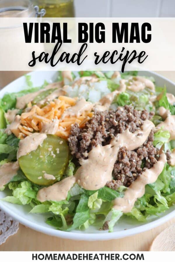 A salad in a bowl featuring lettuce, ground beef, shredded cheese, pickles, diced onions, and a creamy dressing drizzled on top. Text overlay reads, Viral Big Mac salad recipe.
