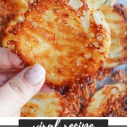 Close-up of a hand holding a crispy onion ring chip with melted cheese, showcasing its golden-brown edges. Several onion ring chips are in the background. Text reads, viral recipe ONION RING CHIPS and HOMEMADEHEATHER.COM is at the bottom.