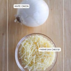 A whole white onion and a bowl of shredded Parmesan cheese on a wooden surface. Labels identify each ingredient.
