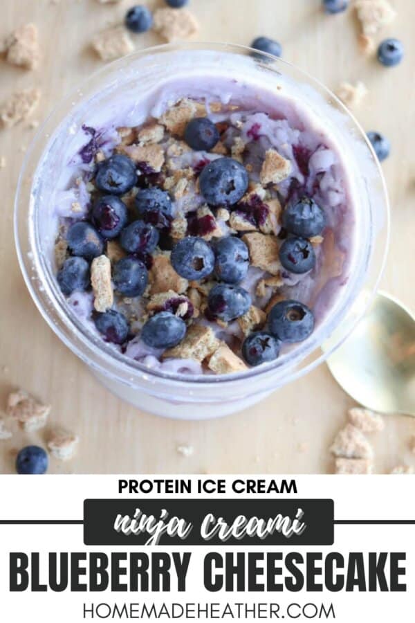 A bowl of blueberry cheesecake ice cream protein-packed and topped with fresh blueberries and crumbled biscuits. A spoon sits beside the bowl. Text reads: Protein Ice Cream Ninja Creami Blueberry Cheesecake homemadeheather.com.