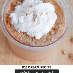 A creamy dessert in a cup topped with whipped cream and a sprinkle of cinnamon or nutmeg. The text reads: Ice Cream Recipe Ninja Creami Pumpkin Pie Cheesecake from Homemade Heather. The background is a wooden surface.