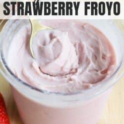 A container filled with pink strawberry frozen yogurt and a spoon, with strawberries beside it. The text reads: High Protein Ninja Creami Strawberry Froyo and homemadeheather.com.