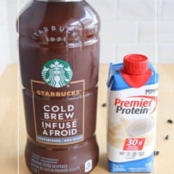 A Starbucks Cold Brew bottle stands beside a Premier Protein carton on a wood surface. Coffee beans are scattered around them. The background shows part of the website name HOMEMADEHEATHER.COM at the bottom.