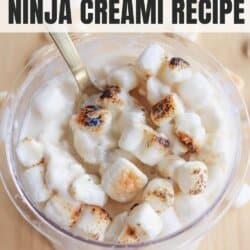 A cup filled with creamy, toasted marshmallow dessert. The golden-brown marshmallows are on top of the dessert, with a spoon inserted. Text overlay reads toasted marshmallow ninja creami recipe and homemade heather.com.