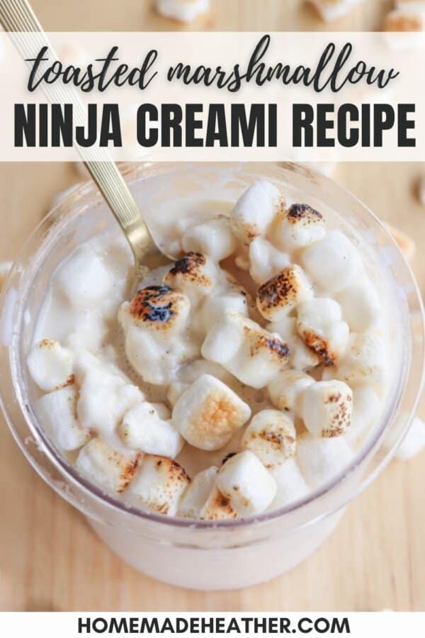 A cup filled with creamy, toasted marshmallow dessert. The golden-brown marshmallows are on top of the dessert, with a spoon inserted. Text overlay reads toasted marshmallow ninja creami recipe and homemade heather.com.