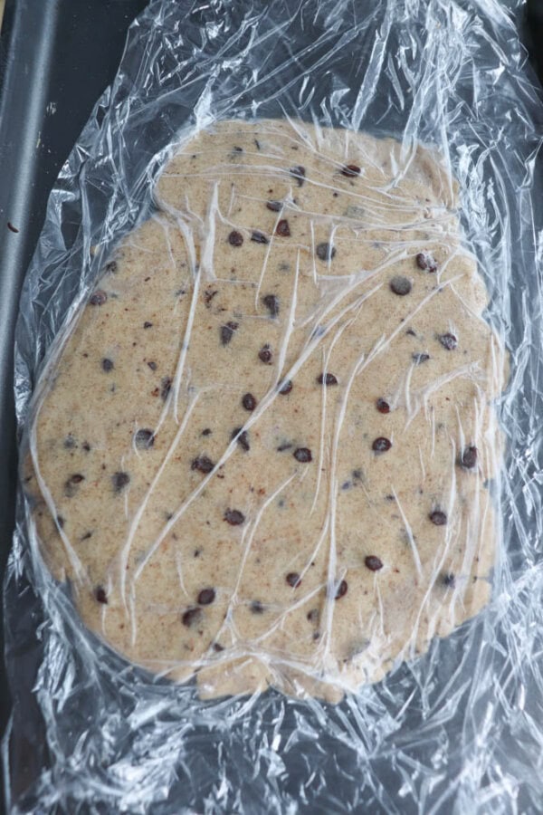 Cookie Dough on a baking sheet covered in plastic wrap.