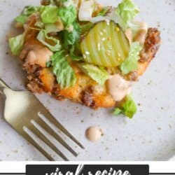 A plate featuring a Big Mac casserole topped with chopped lettuce, pickles, and sauce sits next to a fork. Text on the image reads Viral Recipe Big Mac Casserole homemadeheather.com.