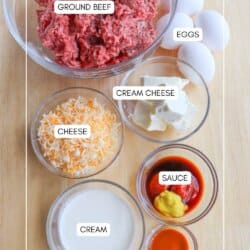 Overhead view of clear bowls containing diced ground beef, four eggs, cream cheese, shredded cheese, sauce, cream, and seasoning. The items are labeled: GROUND BEEF, EGGS, CREAM CHEESE, CHEESE, SAUCE, and CREAM.
