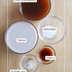 Five labeled bowls on a wooden surface: chai concentrate, cream, sweetener, vanilla, and pudding mix. Ingredients are arranged neatly, each in a clear glass bowl. Website homemadeheather.com is at the bottom.