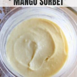 A bowl of creamy mango sorbet with a smooth texture, set on a wooden surface. The top text says ninja creami recipe MANGO SORBET and the bottom text reads HOMEMADEHEATHER.COM. Theres a hint of lace in the background.