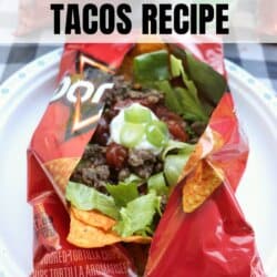 A small bag of Doritos is opened and filled with taco ingredients like ground beef, shredded cheese, salsa, and green onions, sitting on a white plate. Text reads, Easy Walking Tacos Recipe for Camping.