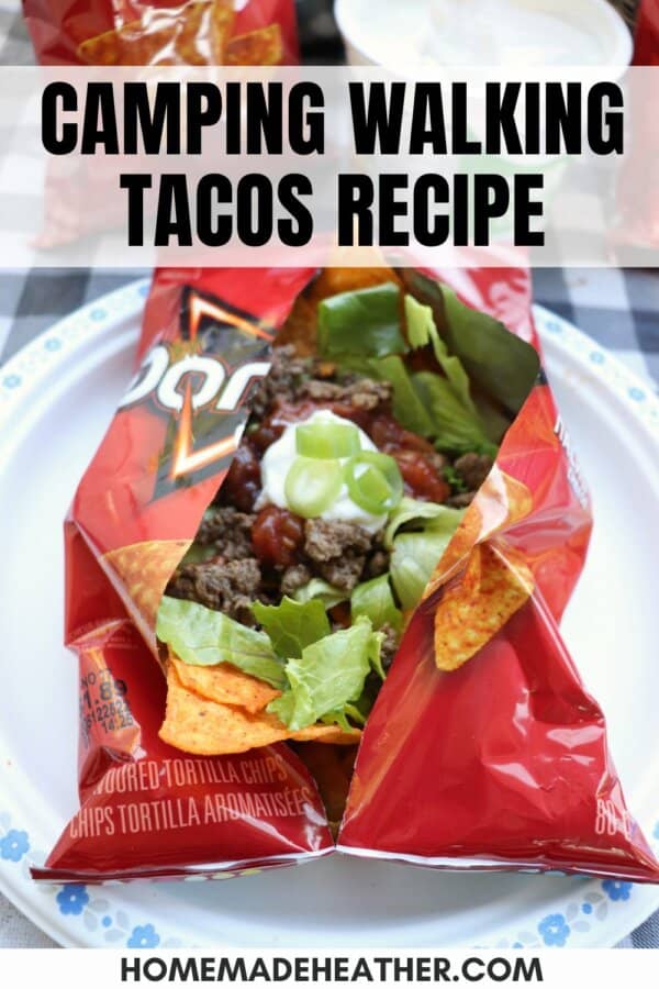 A small bag of Doritos is opened and filled with taco ingredients like ground beef, shredded cheese, salsa, and green onions, sitting on a white plate. Text reads, Easy Walking Tacos Recipe for Camping.