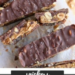 Image of homemade Snickers date bars on parchment paper. The bars feature a chocolate topping, a layer of peanuts, and a base made from dates. Text at the bottom reads Snickers Date Bars from homemadetheater.com.