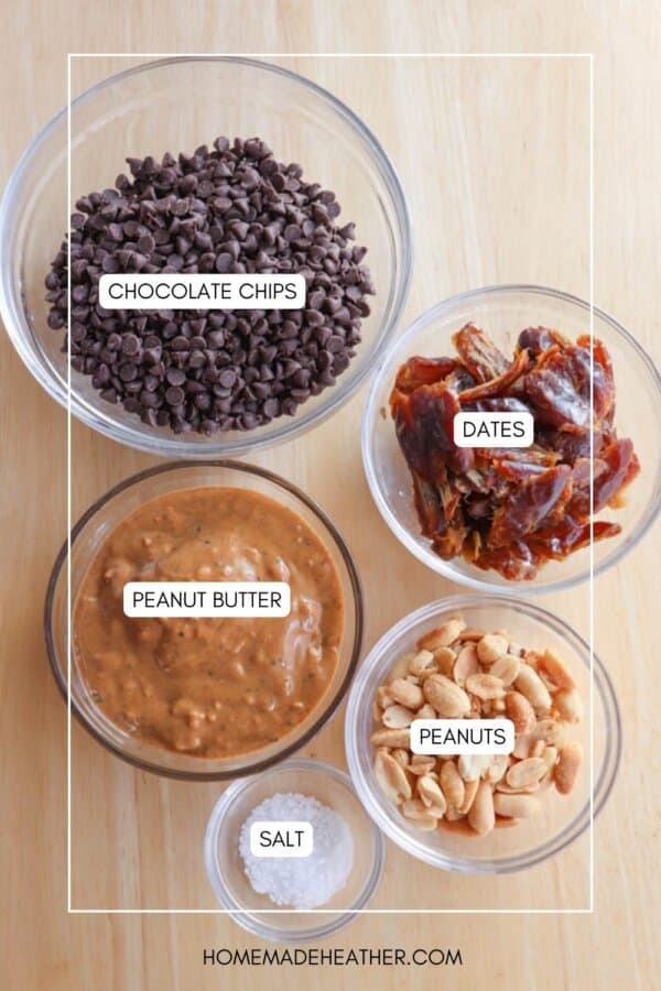 Four bowls containing chocolate chips, dates, peanut butter, and peanuts are labeled. A small pile of salt is nearby. The background is a wooden surface. The text reads homemadeheather.com.