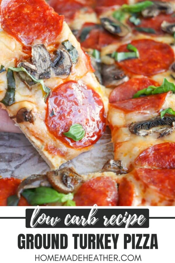 A slice of ground turkey pizza topped with pepperoni, mushrooms, and spinach is being lifted from the whole pizza. The text at the bottom reads: Low carb recipe. Ground turkey pizza. HomemadeHeather.com.