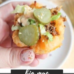 Close-up of a hand holding a tater tot cup filled with ground beef, lettuce, pickles, cheese, and sauce, resembling a Big Mac. Text at the bottom reads big mac tater tot cups and homemadeheather.com.
