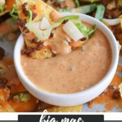 A close-up of a nacho chip topped with ground beef, lettuce, and diced onions being dipped into a creamy, orange Big Mac-style sauce. Text overlay reads: big mac nachos recipe homemadheather.com.