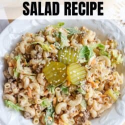 A bowl of Big Mac pasta salad with macaroni, ground beef, lettuce, shredded cheese, and pickles, garnished with pickle slices on top. Text reads Big Mac Pasta Salad Recipe and homemadeheather.com at the bottom.
