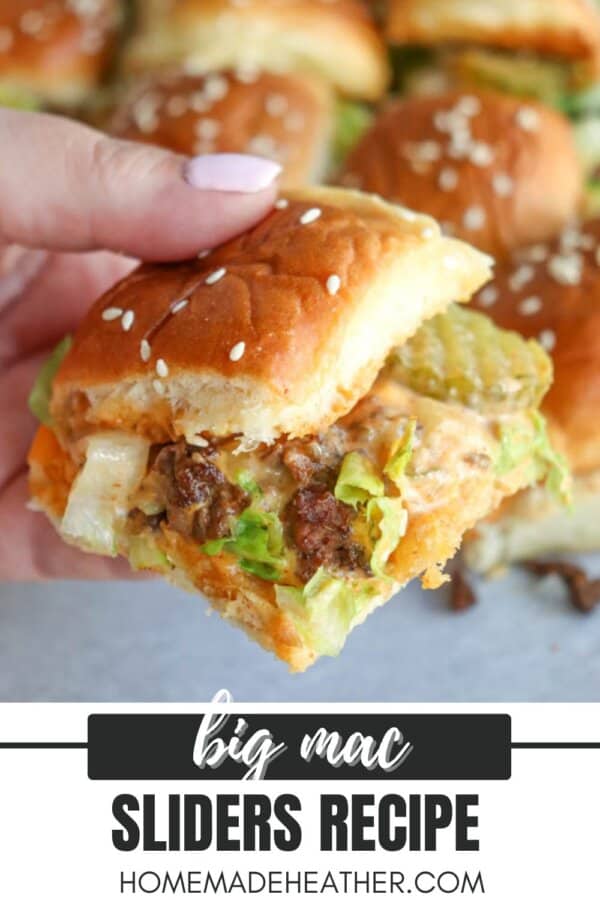 A hand holding a mini sandwich made with a sesame seed bun, ground beef, lettuce, cheese, pickles, and sauce. Other similar sliders are visible in the background. Text reads: Big Mac Sliders Recipe, homemadeheather.com.