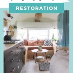 A cozy, renovated 1975 Argosy Airstream interior featuring a small kitchen, L-shaped seating with cushions, a round table, plants, and light wooden accentsโan inviting space that highlights expert Argosy Airstream restoration.