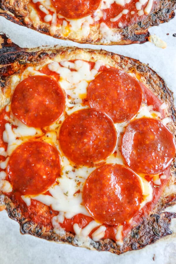 Close-up of a pepperoni pizza with melted cheese and tomato sauce on a crust that is golden brown and slightly crispy at the edges.