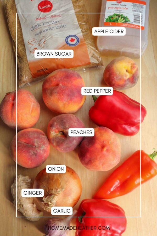 A top-down view of ingredients on a wooden surface, including brown sugar, apple cider, red bell peppers, peaches, an onion, ginger, and garlic, each labeled with white text boxes.