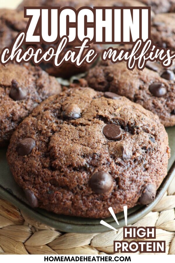 Close-up of chocolate zucchini muffins topped with chocolate chips on a woven mat. Text reads, “Zucchini chocolate muffins, high protein.” The bottom displays the website name “homemadeheather.com.”.