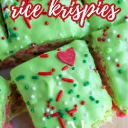 Close-up of bright green rice krispies treats topped with red and green sprinkles and red heart candies. Bold text says Grinch rice krispies with SO GOOD! at the bottom. Website: homemadeheather.com.