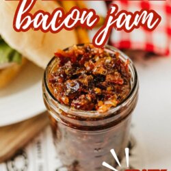 A jar of homemade bacon jam sits on a table next to a sandwich. Text on the image reads Homemade bacon jam and Crazy good! with the website homemadheather.com at the bottom.