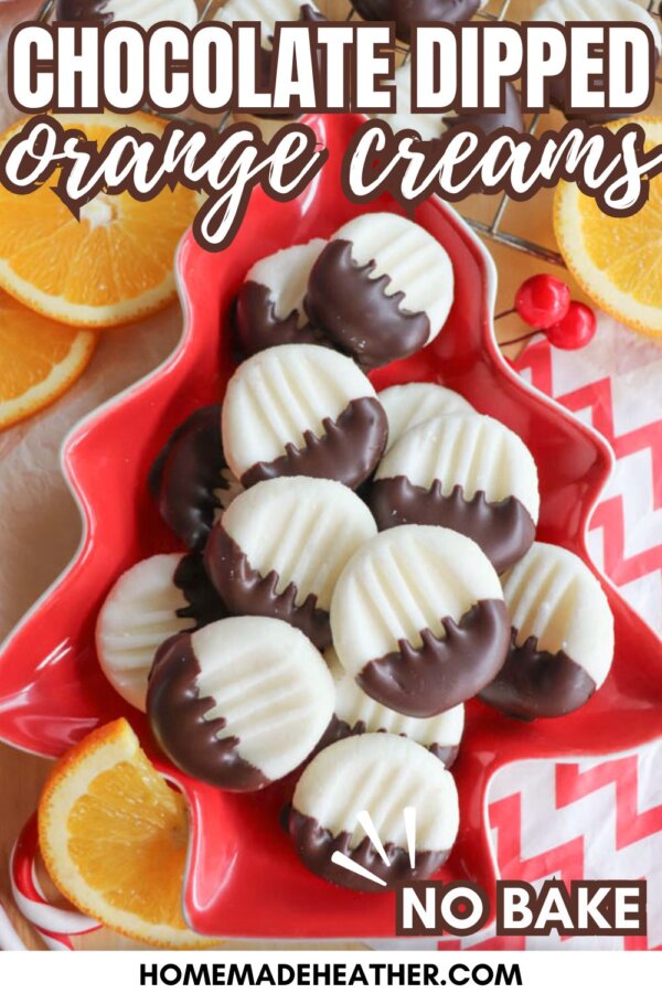 A star-shaped red dish holds round, white chocolate-dipped orange cream cookies with fork marks. Orange slices and a festive napkin are nearby. Text reads: โChocolate Dipped Orange Creams, NO BAKE, homemadeheather.com.โ.