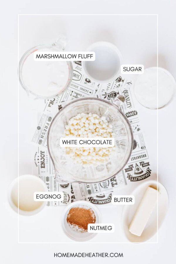 Overhead view of ingredients in bowls: marshmallow fluff, sugar, white chocolate chips, eggnog, butter, and nutmeg arranged on a white surface with labeled text identifying each ingredient.