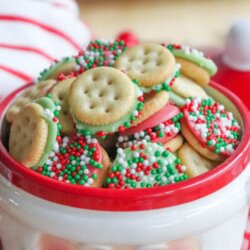 A festive Santa-shaped jar filled with mini Ritz crackers coated in chocolate and topped with red, green, and white sprinkles. The words Mini Ritz freckles appear above the jar.