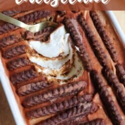 A rectangular dish of Biscoff yogurt cheesecake is topped with rows of Biscoff cookies. A spoon has scooped out a portion, revealing the creamy cheesecake layer underneath. The image includes text with the recipe name.