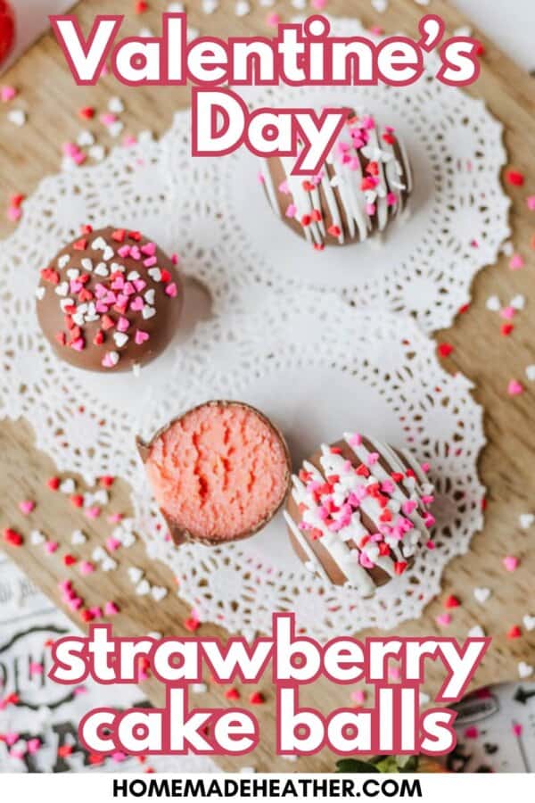 Three strawberry cake balls, one cut open to show the pink inside, are decorated with white and pink sprinkles and placed on a doily. Text reads Valentine’s Day strawberry cake balls.