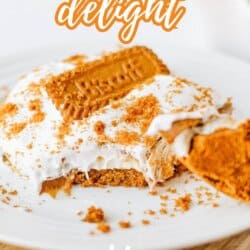 A slice of Biscoff Cookie Butter Delight topped with creamy filling, cookie pieces, and a whole Biscoff cookie on a white plate. Text reads Biscoff Cookie Delight and So Easy.