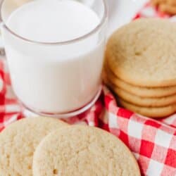 A stack of snickerdoodle cookies and a glass of milk sit on a red and white checkered cloth. Text at the top reads Snickerdoodle cookie recipe and the bottom shows homemadeheather.com.