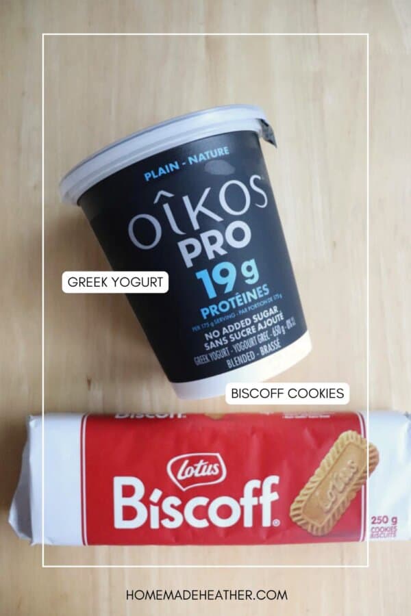 A container of Oikos Pro Greek yogurt and a package of Lotus Biscoff cookies are placed on a light wooden surface. Labels point to each item, identifying them as Greek yogurt and Biscoff cookies.