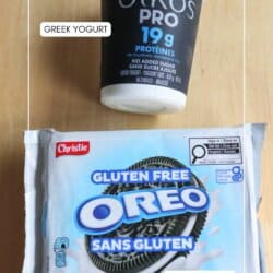 A container of Oikos Pro Greek yogurt and a package of gluten free Oreo cookies are placed on a wooden surface. The items are labeled with text indicating Greek Yogurt and Oreo Cookies.