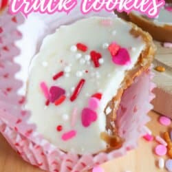 A close-up of a Valentines-themed cookie with white icing and colorful heart-shaped sprinkles in a pink cupcake liner. Text reads โValentineโs crack cookiesโ and โSo good!โ with the website homemadeheather.com at the bottom.