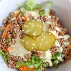 A bowl filled with sweet potato, ground meat, shredded lettuce, cheese, sauce, and topped with sliced pickles. Text on image reads Sweet Potato Big Mac Bowl and homemadeheather.com.
