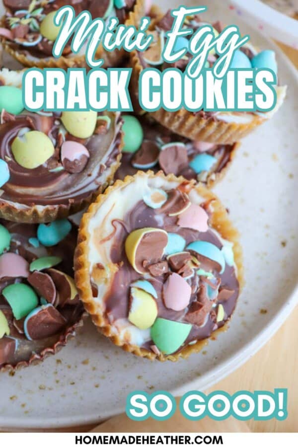 A plate of chocolate and white chocolate cookies topped with colorful candy-coated mini eggs, labeled “Mini Egg Crack Cookies” and “So good!” with the website homemadewithheather.com at the bottom.