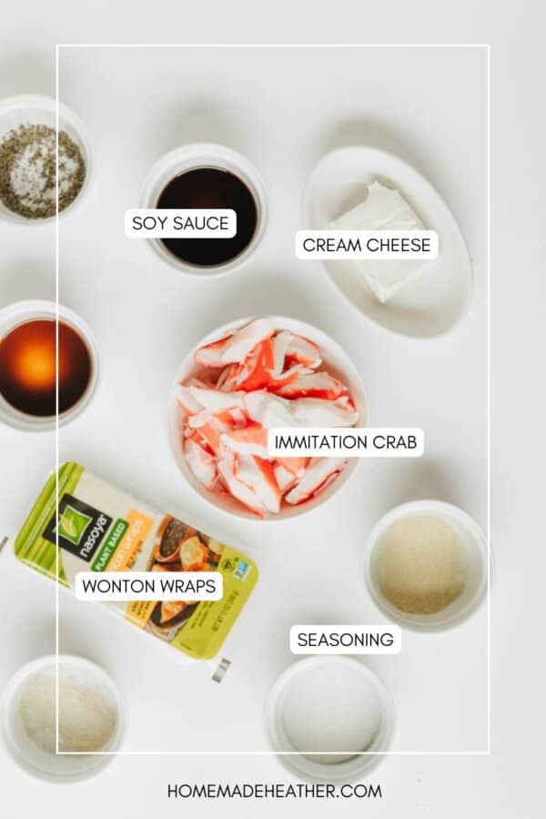 Top-down view of ingredients for crab rangoon: soy sauce, cream cheese, imitation crab, wonton wraps, seasoning, and a small bowl of sauce, all labeled and arranged on a white surface.