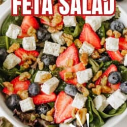 A bowl of salad with fresh spinach, sliced strawberries, blueberries, feta cheese cubes, and walnuts. Bold text reads Strawberry Feta Salad with a Tiktok Recipe label and homemadHeather.com at the bottom.