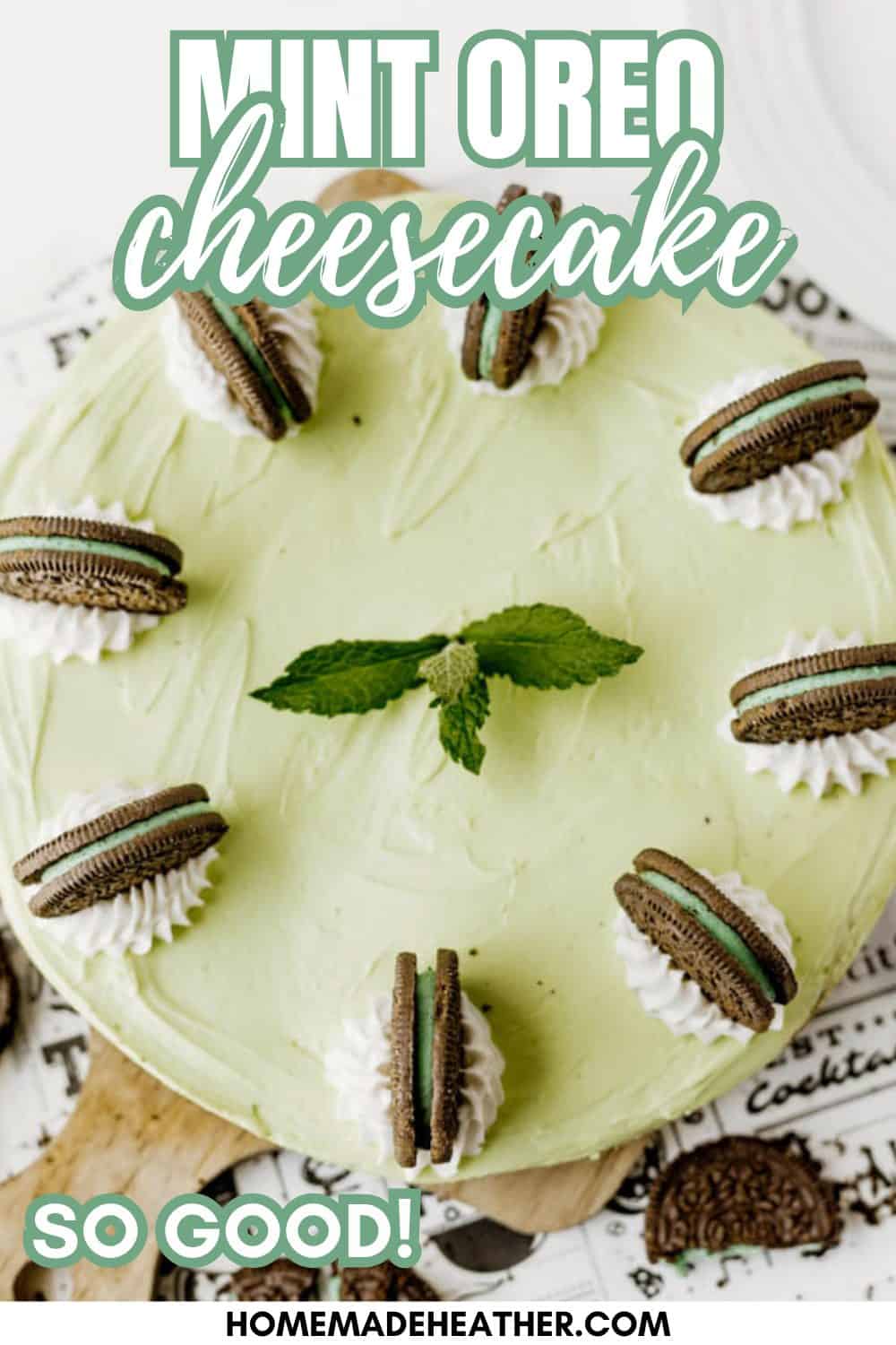 A mint Oreo cheesecake topped with dollops of whipped cream and mint Oreo cookies, garnished with fresh mint leaves, displayed on a white surface with Mint Oreo Cheesecake written above and So Good! homemadeheather.com at the bottom.