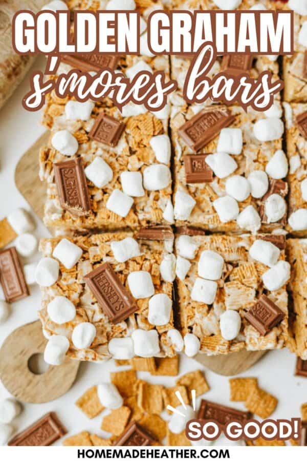 Top-down view of sliced Golden Graham smores bars topped with mini marshmallows and chocolate pieces on a cutting board, with extra cereal and marshmallows scattered around. Text reads Golden Graham smores bars.