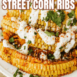 Close-up of Mexican street corn ribs stacked on a plate, topped with creamy sauce, chopped cilantro, and sprinkled spices. Text overlay reads “Mexican Street Corn Ribs So Good!” with a website link at the bottom.