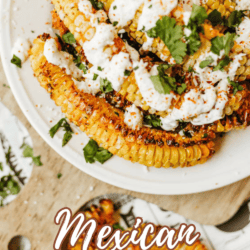A plate of grilled corn ribs topped with creamy sauce and chopped cilantro, sprinkled with seasoning. Text on the image reads “Mexican Street Corn Ribs” and “homemadeheather.com”.