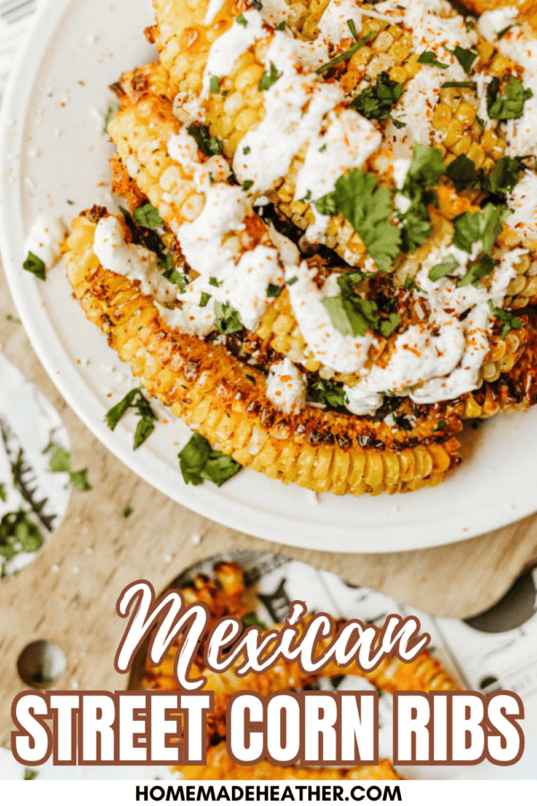 A plate of grilled corn ribs topped with creamy sauce and chopped cilantro, sprinkled with seasoning. Text on the image reads “Mexican Street Corn Ribs” and “homemadeheather.com”.