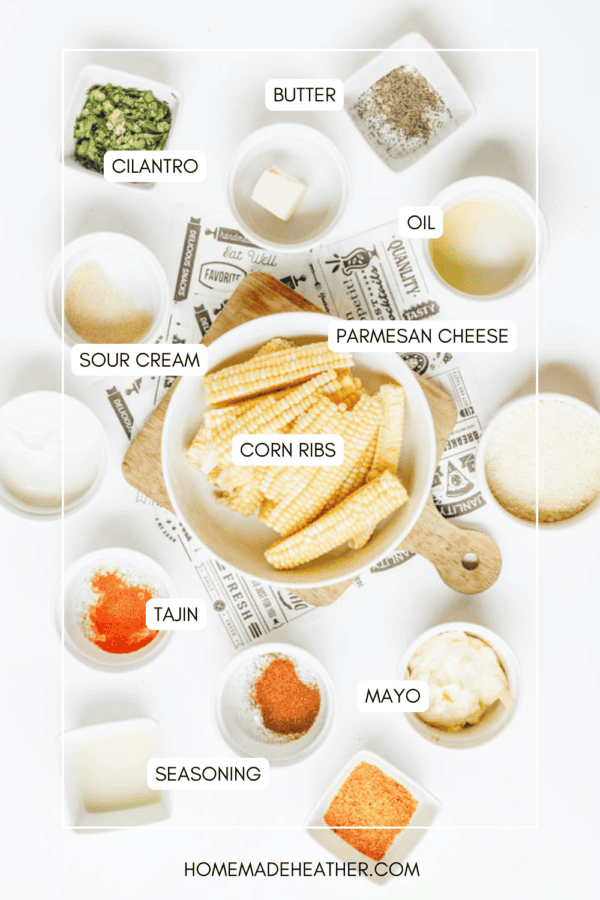 A flat lay of labeled ingredients for corn ribs, including corn, cilantro, butter, oil, parmesan cheese, sour cream, mayo, tajin, seasoning, and sugar in small bowls on a white background.